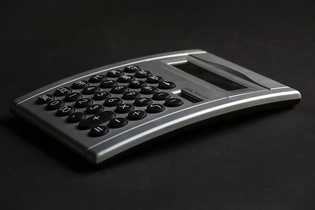 Calculatrice et documents financiers symbolisant le calcul des plafonds PER et des déductions fiscales